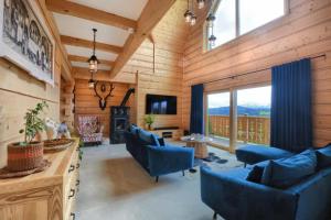 a living room with wooden walls and blue chairs at Widokówka Kluszkowce in Kluszkowce
