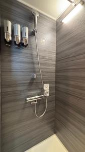 福岡市にあるHotel Edge Nakasuの茶色の壁のバスルーム(シャワー付)