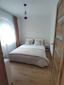 シュツァブニツァにあるApartamenty JULKAのベッドと窓のある白い寝室