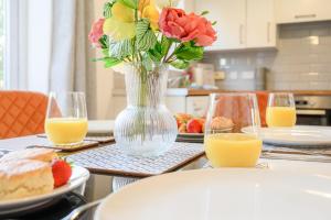 une table avec un vase de fleurs et du jus d'orange dans l'établissement Quiet House, PRKG-3 Cars, Contractors & Families, York Centre 10mins, à York