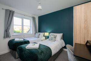 une chambre d'hôtel avec deux lits et une fenêtre dans l'établissement Quiet House, PRKG-3 Cars, Contractors & Families, York Centre 10mins, à York