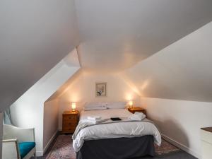 a bedroom with a bed with white sheets and pillows at Ivy House in Kingussie