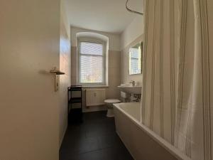 a bathroom with a tub and a toilet and a sink at Moderne 2-Zimmer Wohnung nahe Zentrum in Chemnitz