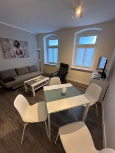a living room with a couch and a table and chairs at Moderne 2-Zimmer Wohnung nahe Zentrum in Chemnitz