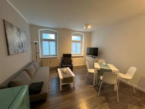 a living room with a couch and a table at Moderne 2-Zimmer Wohnung nahe Zentrum in Chemnitz