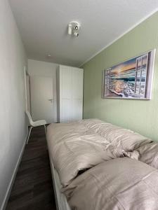 a bedroom with a bed with a picture on the wall at Moderne 2-Zimmer Wohnung nahe Zentrum in Chemnitz