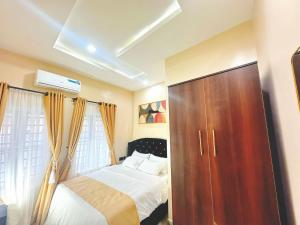 una camera da letto con un letto e un armadio in legno di La Vintage Apartelle - Apartment Paris a Ikeja