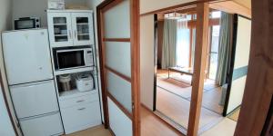 a room with a refrigerator and a mirror at 布施温泉ステイ　ウエスト in Saku