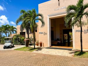 a golf cart parked outside of a building with palm trees at Vipingo Ridge, The Maridi Villa by Diplo El Homes in Pingilikani