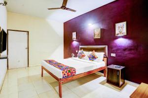 GoaにあるFabHotel Elvin Balaji Beach Palaceの紫の壁のベッドルーム1室(ベッド1台付)