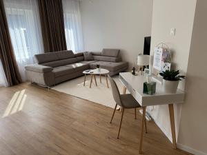 a living room with a couch and a table at Európa Apartman Mini in Békéscsaba