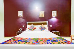 GoaにあるFabHotel Elvin Balaji Beach Palaceの紫の壁のベッドルーム1室(大型ベッド1台付)