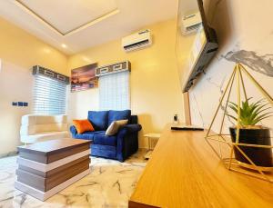 un soggiorno con un divano blu e una TV di La Vintage Apartelle - Apartment Paris a Ikeja