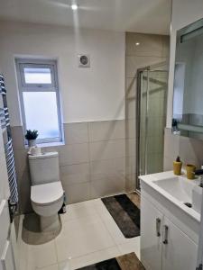 Un baño con inodoro, ducha y lavabo. en Bright 2-Bed Flat with Free Parking near Whetstone, en New Barnet 2 fotos más