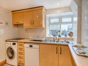a kitchen with a sink and a washing machine at Steppe Haugh in Hawes