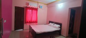 a room with a bed with a red window at KR HOTEL AND BANQUET Hall in Dhanbād