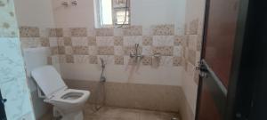 a small bathroom with a toilet and a shower at KR HOTEL AND BANQUET Hall in Dhanbād