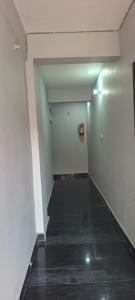 an empty hallway with a white wall and a door at KR HOTEL AND BANQUET Hall in Dhanbād