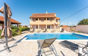 a villa with a swimming pool in front of a house at 5 Bedroom Cozy Home In Biograd Na Moru in Biograd na Moru +37 photos