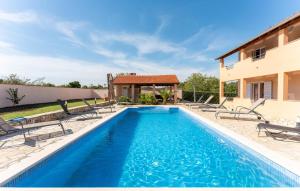 a villa with a swimming pool and a house at 5 Bedroom Cozy Home In Biograd Na Moru in Biograd na Moru