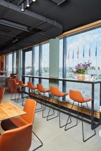 a row of chairs and tables in a room with windows at Keruen inn Merke in Aktokan