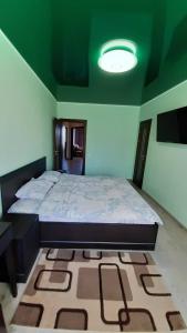 a bedroom with a large bed and a green ceiling at Apart in Ivano-Frankivsʼk