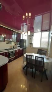 a kitchen with a table and chairs in a kitchen at Apart in Ivano-Frankivsʼk