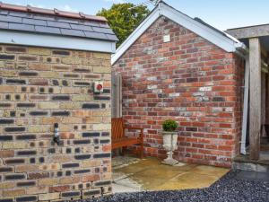 a brick wall with a bench in the corner at Y Golchdy in Llangadog