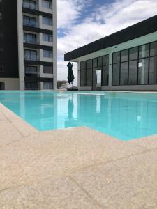 a large swimming pool in front of a building at Reily Luxury Homes - Studio Apartment, Syokimau near JKIA & SGR, PARK VIEW in Nairobi +1 photo