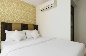 a white bed with white pillows in a bedroom at Hotel Melaka INN in Melaka