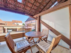 eine Terrasse mit Tisch und Stühlen auf einem Balkon in der Unterkunft L'ECRIN DU BONHEUR - Neuf - Tout confort - Parking - Proche de Strasbourg - Spacieux - Proche Transports in Stutzheim
