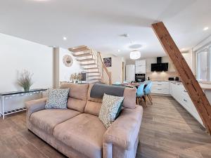 ein Wohnzimmer mit Couch und Küche in der Unterkunft L'ECRIN DU BONHEUR - Neuf - Tout confort - Parking - Proche de Strasbourg - Spacieux - Proche Transports in Stutzheim