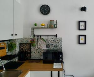 a kitchen with a microwave and a clock on the wall at Zmaj 16 in Divčibare +7 photos