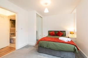 a bedroom with a large bed with red pillows at Private stylish flat in Romford - Free parking, 5 min walk Elizabeth line in Romford