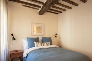 a bedroom with a bed with blue sheets at Casa Allegra - luxury apartment in the centre of Pietrasanta in Pietrasanta