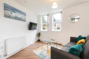 a living room with a couch and a table at Private stylish flat in Romford - Free parking, 5 min walk Elizabeth line in Romford