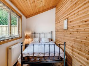 a bed in a room with a wooden wall at Mayfield Lodge - Uk39917 in Heckington
