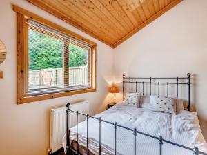 a bedroom with a bed and a window at Mayfield Lodge - Uk39917 in Heckington +8 photos