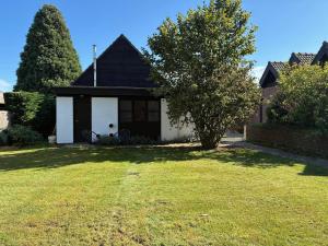 a small house with a grass yard in front of it at Cozy house in Olmen in Balen