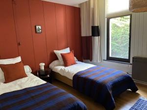 a hotel room with two beds and a window at Cozy house in Olmen in Balen