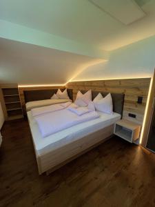 a bedroom with a bed with white sheets and pillows at Haus Gruber in Altenmarkt im Pongau