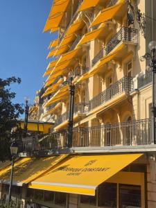 a building with yellow awnings on the side of it at Petit studio centre ville in Montreux