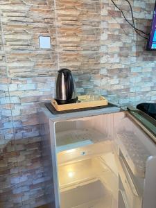 ein Kühlschrank, auf dem eine Teekanne steht in der Unterkunft ABI Hotel4 - 1 minute to the Beach and 1 second to the Mall in Ngurah Rai International Airport