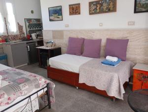 a bedroom with a bed with purple pillows and a table at Athinas Art House in Kolymbia