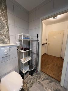 a bathroom with a toilet and a room with a door at LuxusCityApartment in Berlin