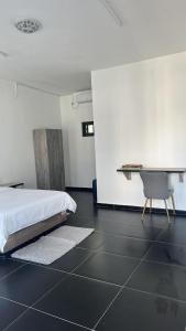 Un dormitorio con una cama, un escritorio y una silla. en Massinga Guest House, en Massinga