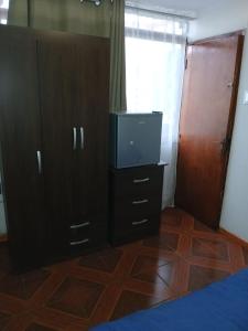a bedroom with a bed and a dresser with a tv at HabitacionIndependiente in El Cerrillo