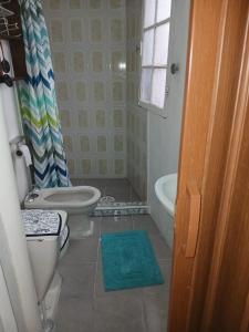 a bathroom with a toilet and a tub and a sink at HabitacionIndependiente in El Cerrillo