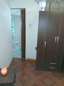 a large wooden cabinet in a room with a bathroom at HabitacionIndependiente in El Cerrillo