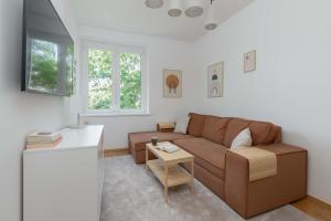 ein Wohnzimmer mit Sofa und Tisch in der Unterkunft Atmospheric Apartment in a Green Area Pet-friendly by Noclegi Renters in Wzgórze Nowotki